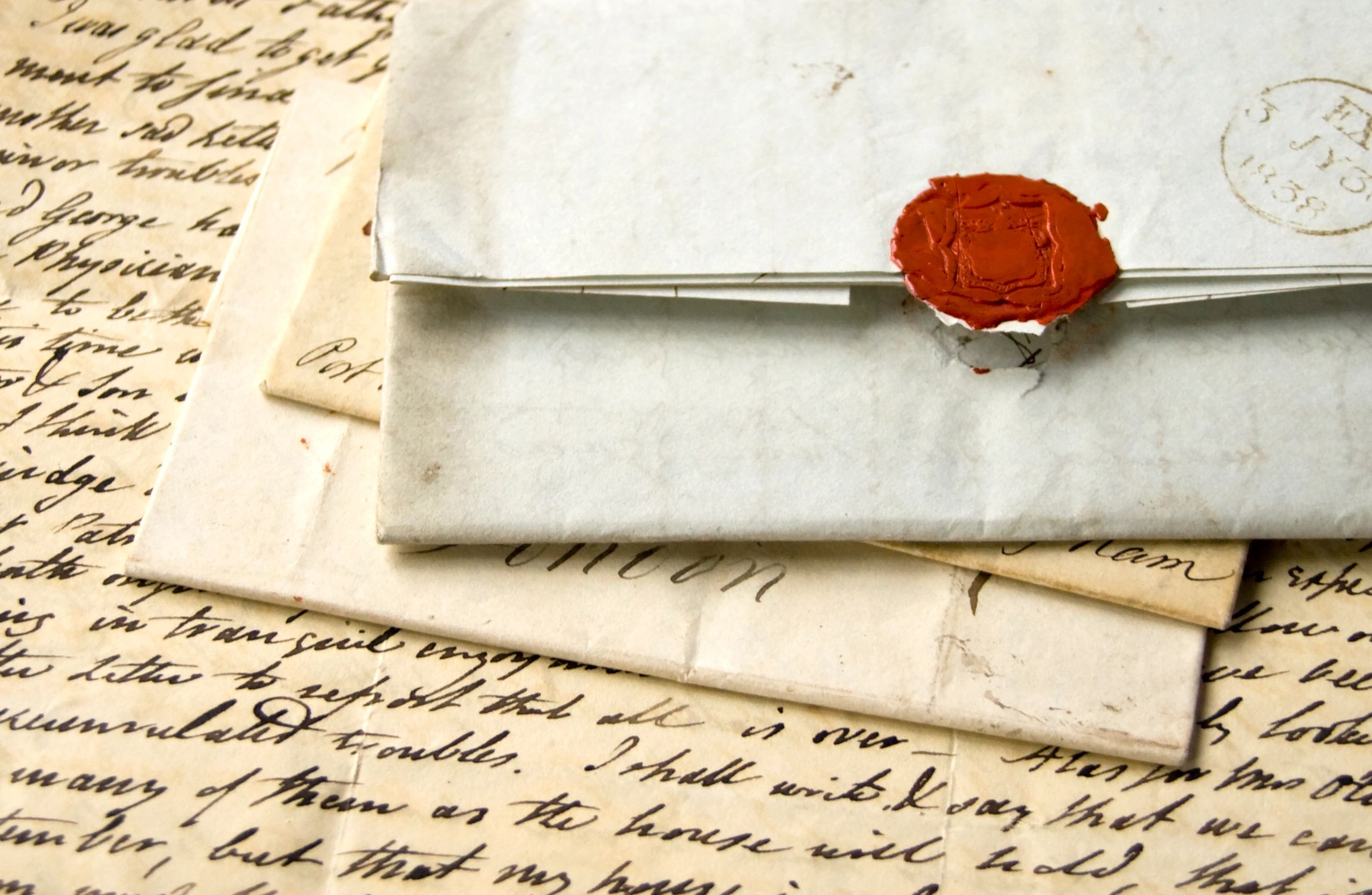 Stack of old handwritten letters with a wax seal