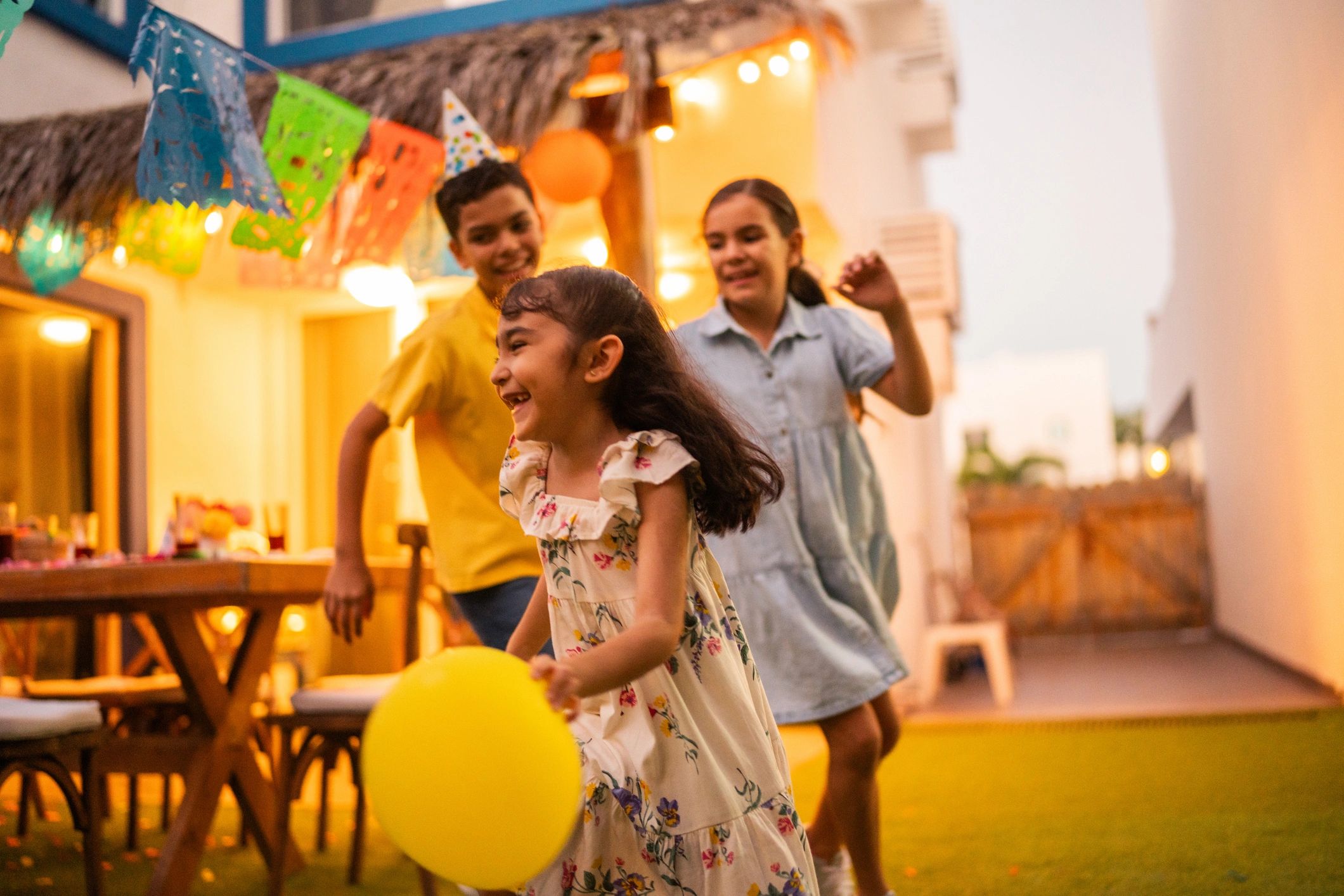 Kids running and playing with balloons at an outdoor party