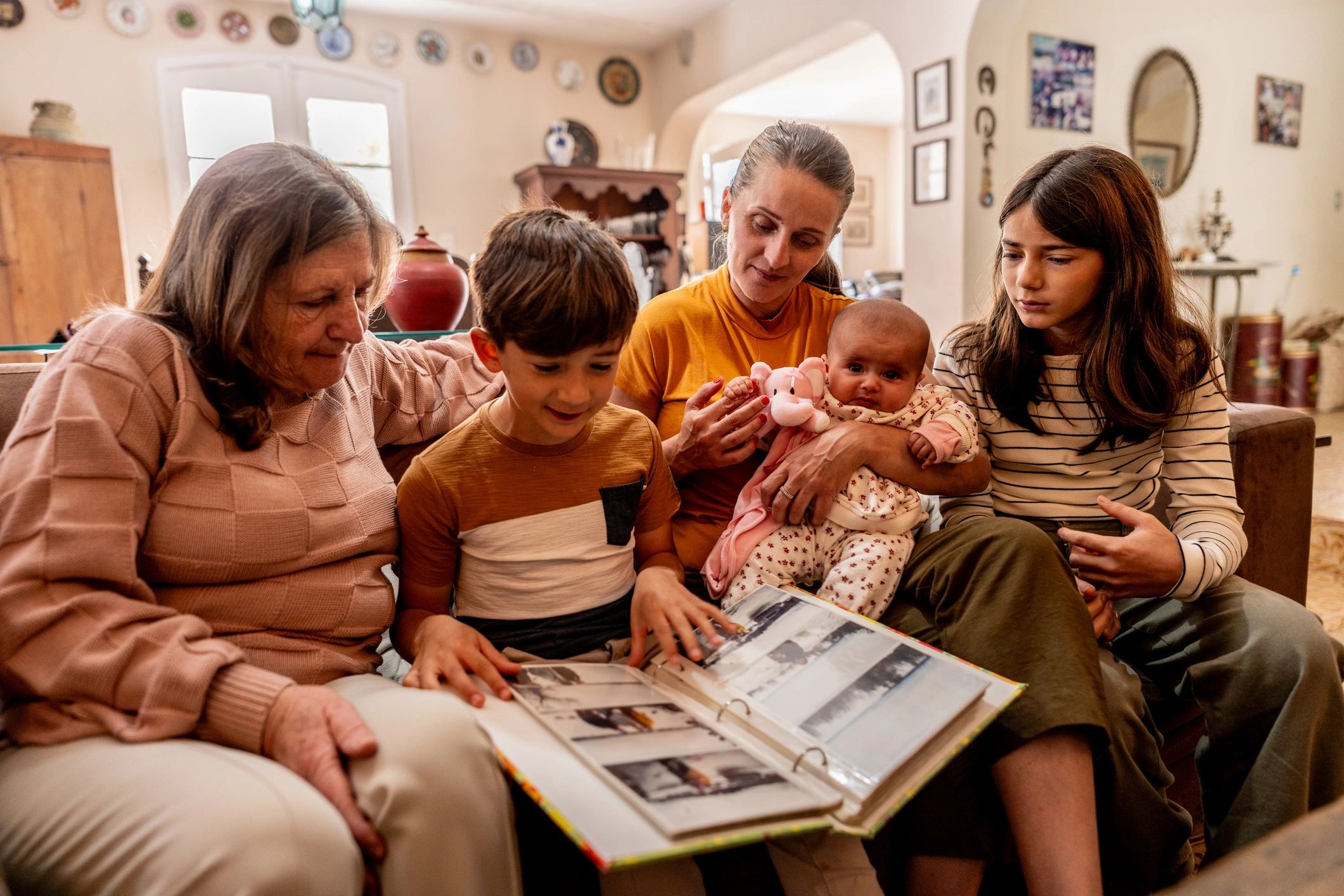 Family looking at a photo album together at home