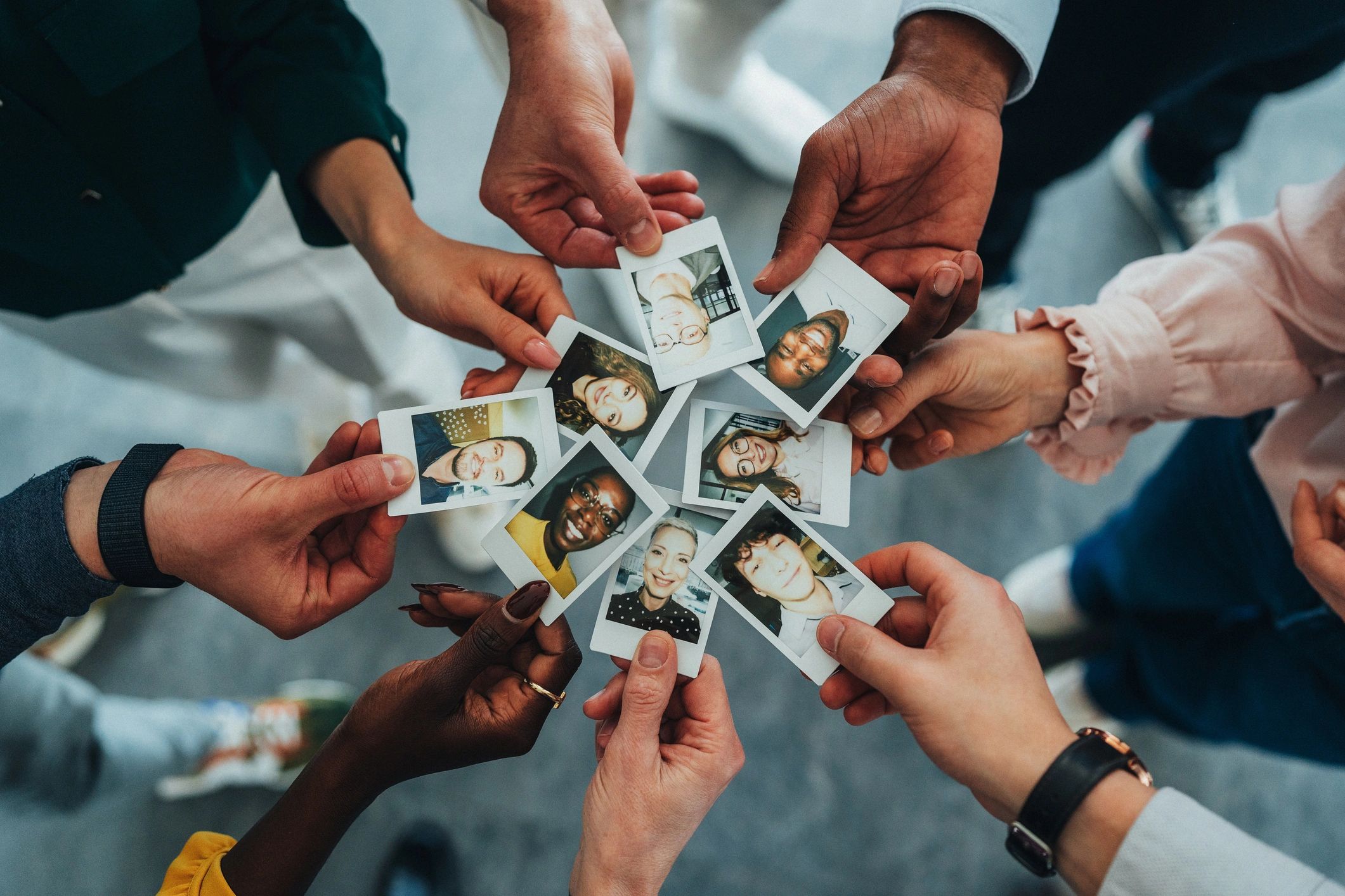 Hands holding instant photos in a circle to symbolize shared memories
