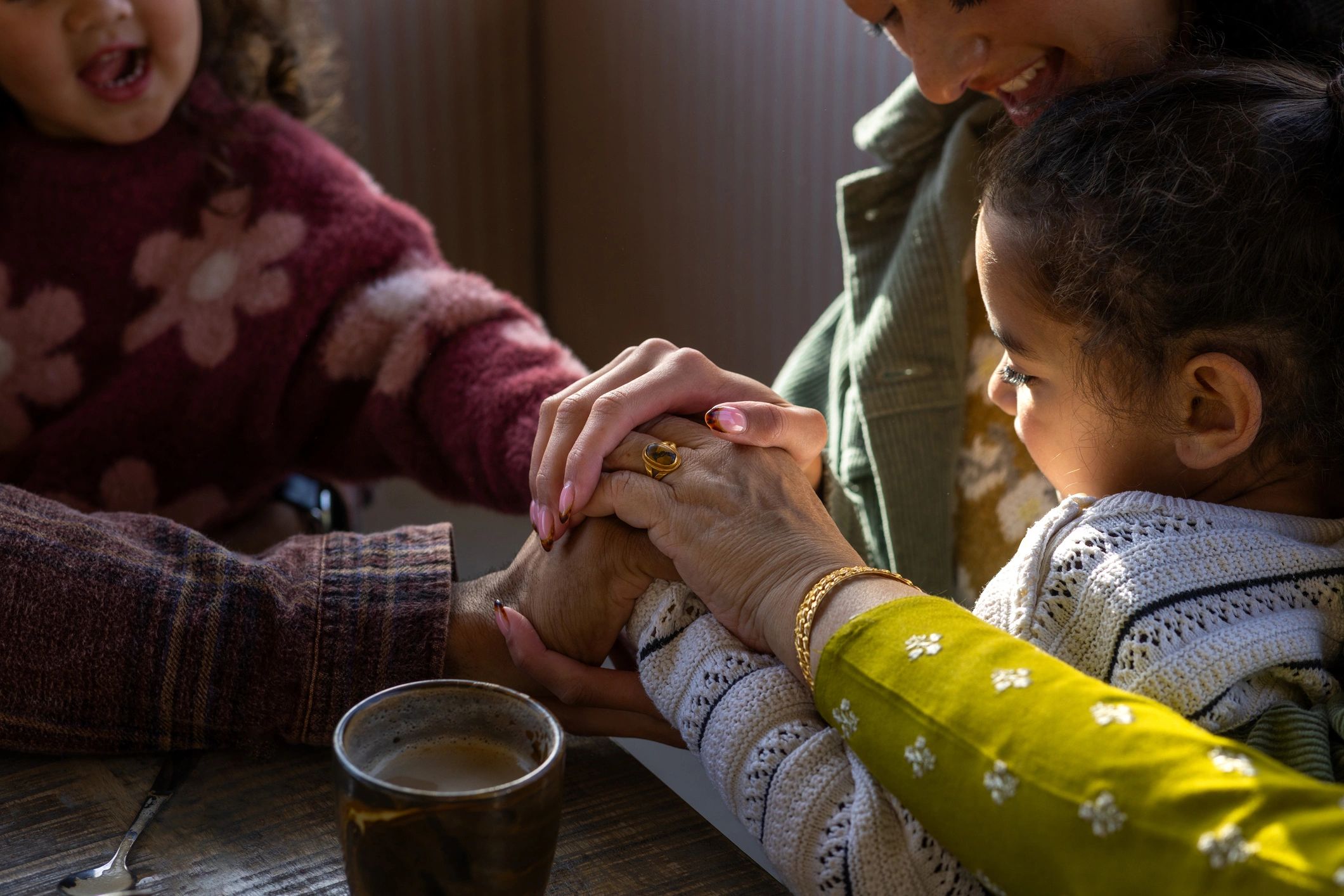 Family members stacking hands together at a table