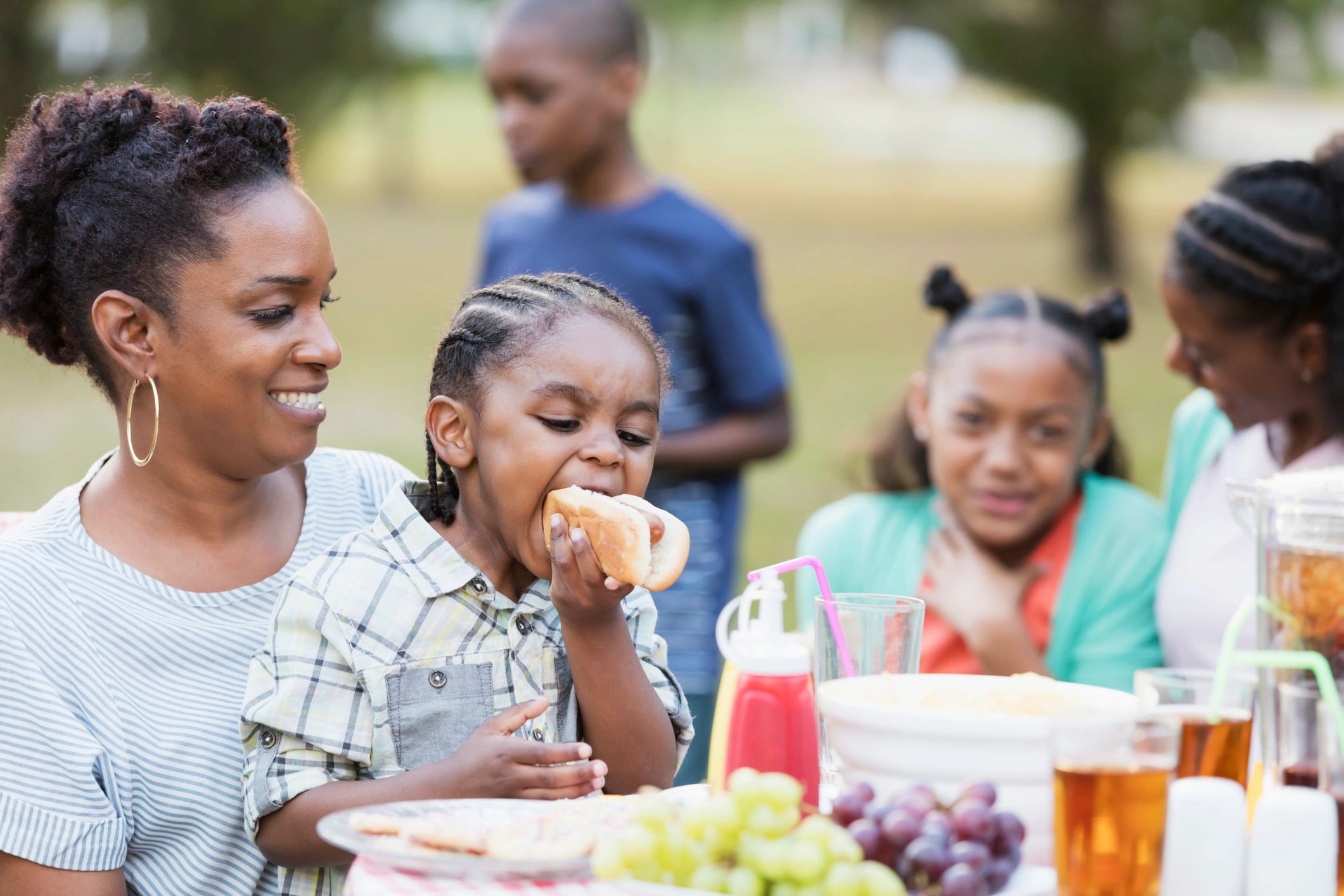 Family members sharing food at an outdoor gathering